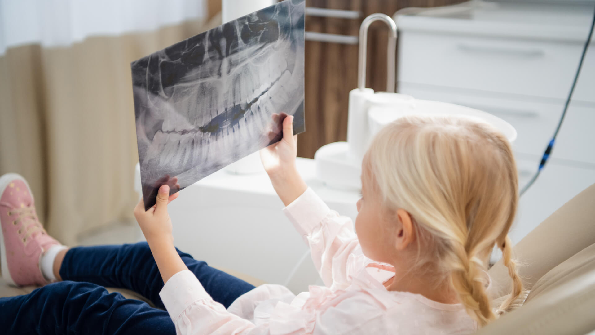 little blonde girl watching a panoramic xray picture